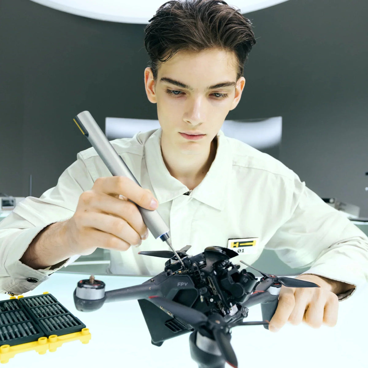 Technik naprawia drona FPV za pomocą precyzyjnego śrubokręta w profesjonalnym warsztacie
