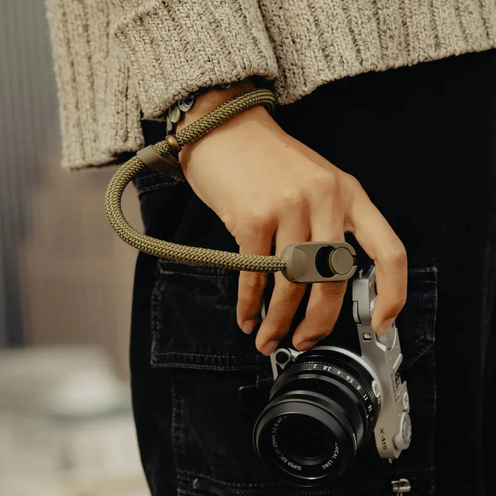 Zielony pasek do aparatu Fujifilm X-M5 w ręce, idealny akcesorium fotograficzne