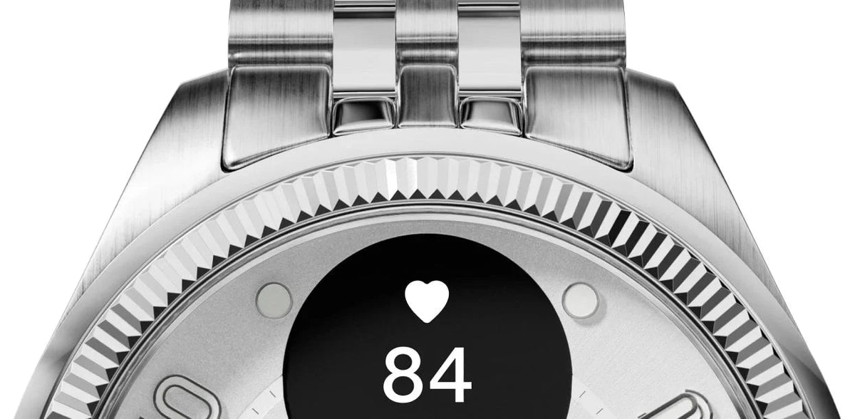 Srebrny zegarek smartwatch z ekranem pokazującym tętno 84 i ikonę serca, idealny do home office