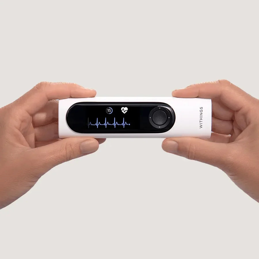 Biały urządzenie Withings do monitorowania tętna i EKG w dłoniach, idealne dla zdrowego stylu życia
