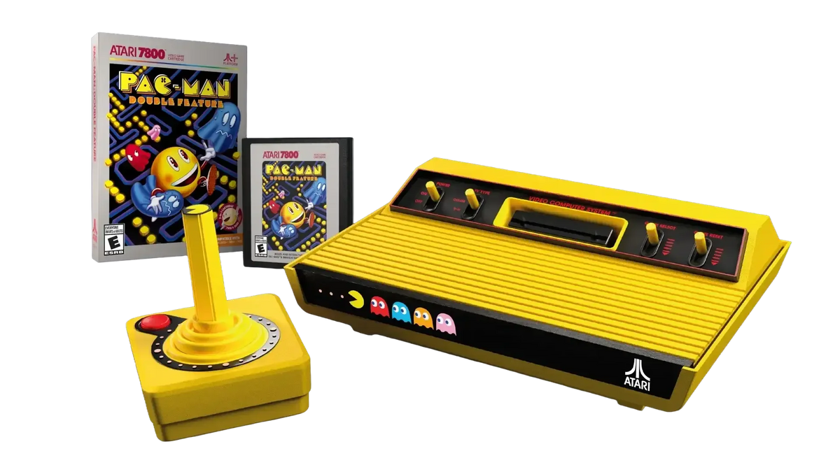 Żółta konsola Atari 7800 z joystickiem i grą Pac-Man, retro gaming, idealna do domowego biura